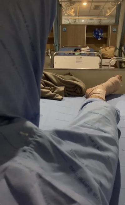 Leg and bandaged foot on hospital bed at night