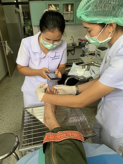 Two nurses fotographing wound on foot